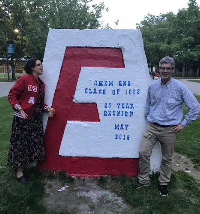 two alumni posing in front of the the Engineers’ Cairn on Main Mall.