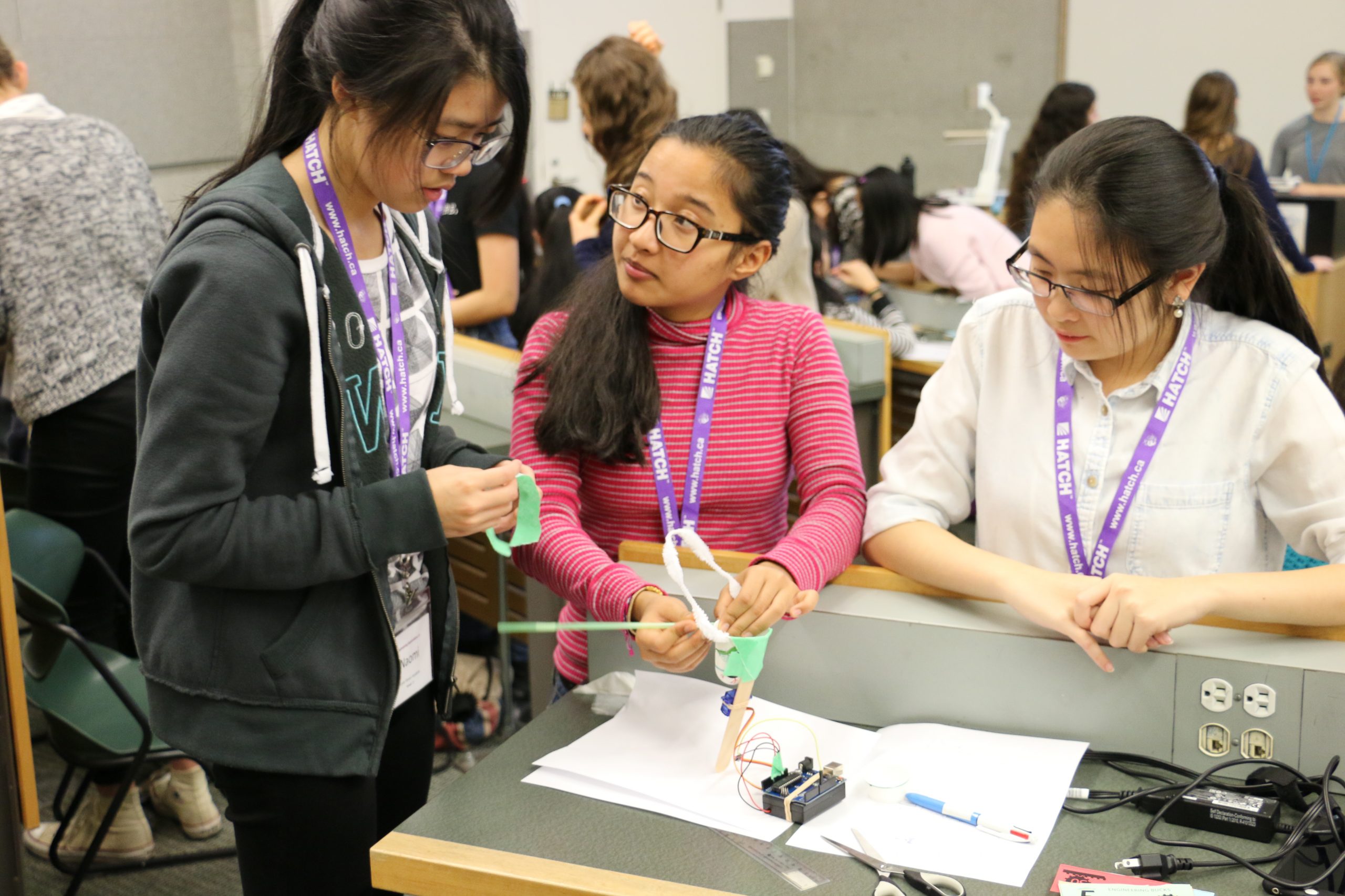 two children and an adult gathered around a science experiment
