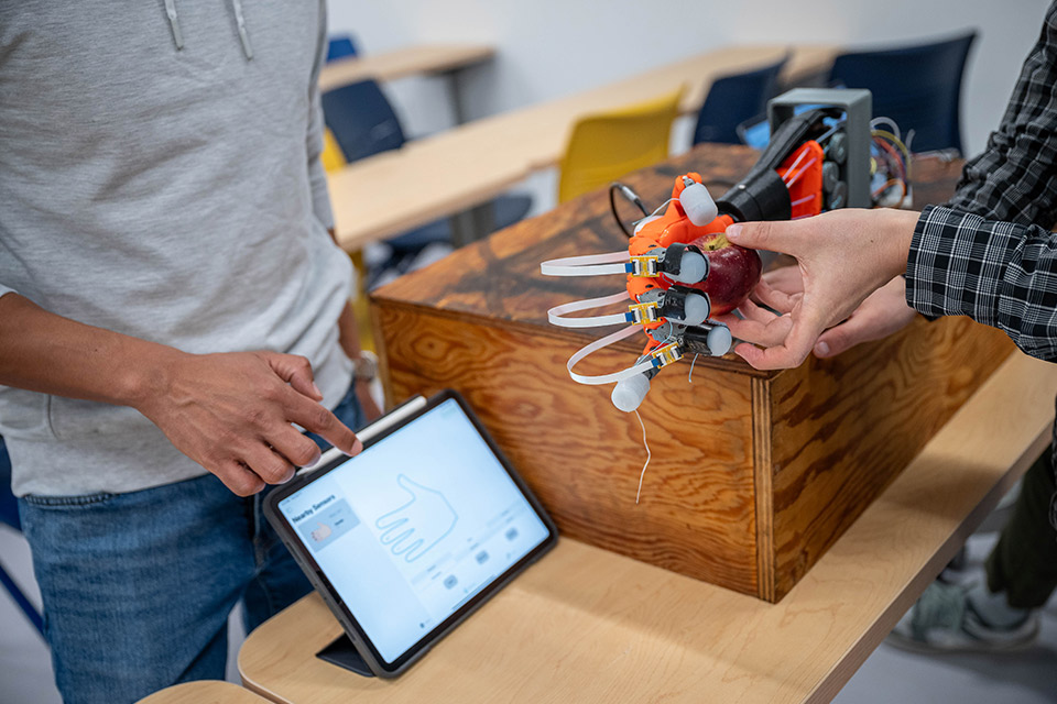 Robotic hand with artificial skin sensors correctly detects how much pressure is needed to hold an apple