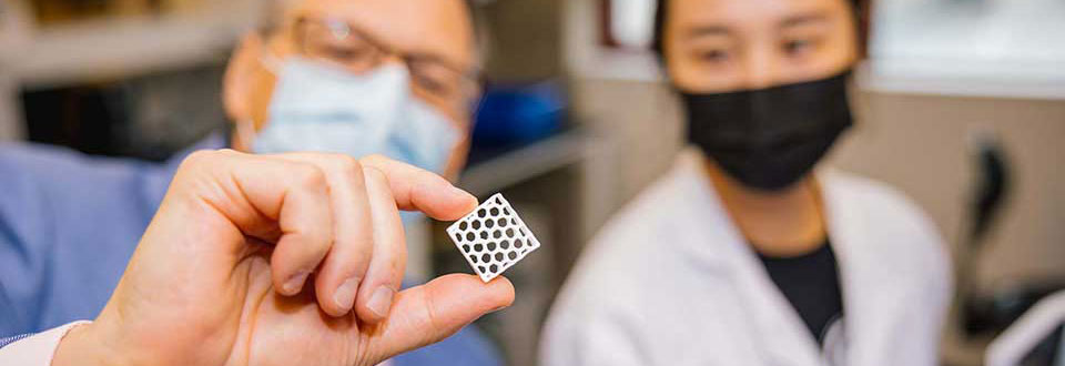 Two researchers looking at an intricate part.