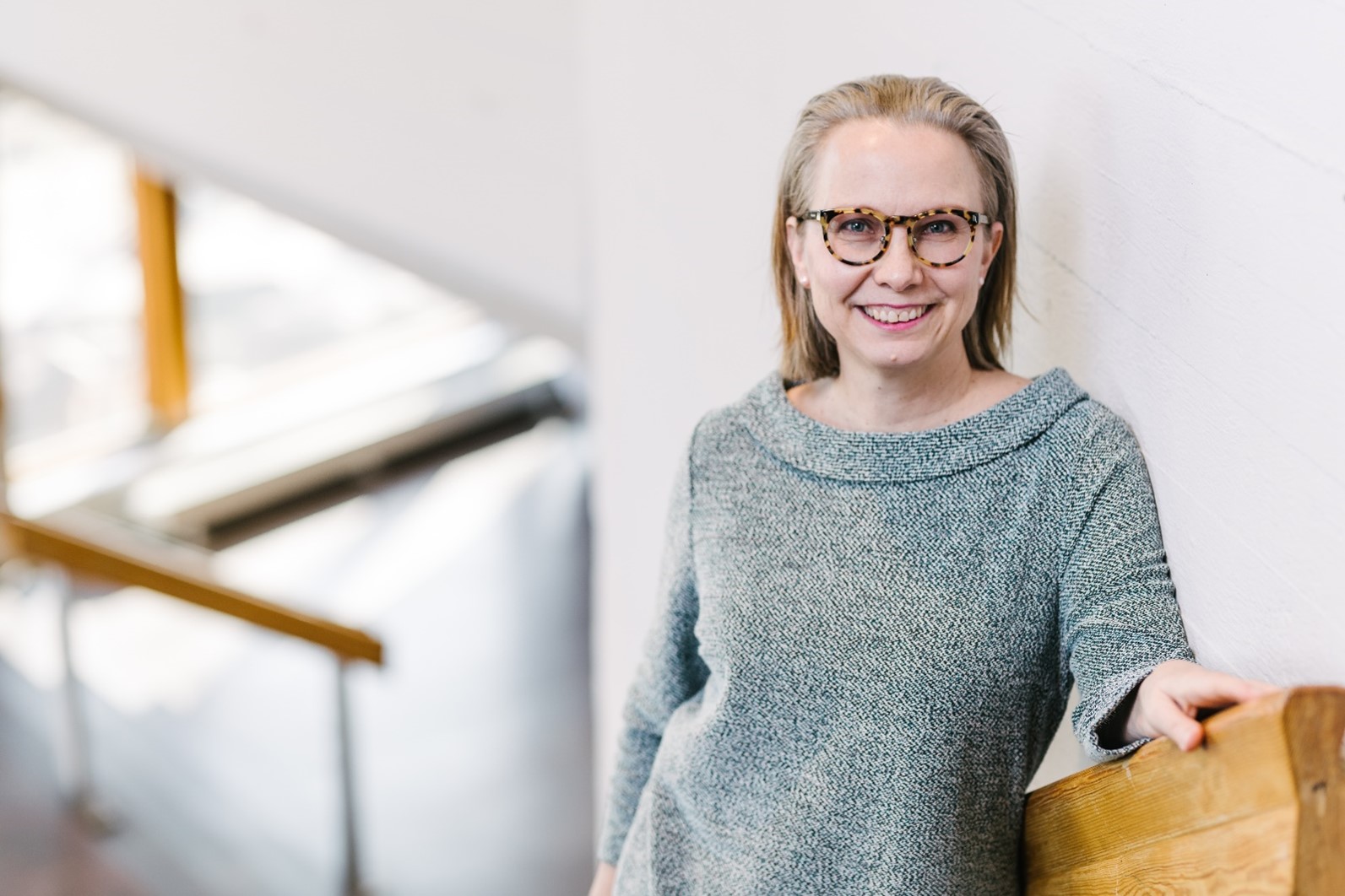 Woman in fancy sweater on staircase in academic atrium