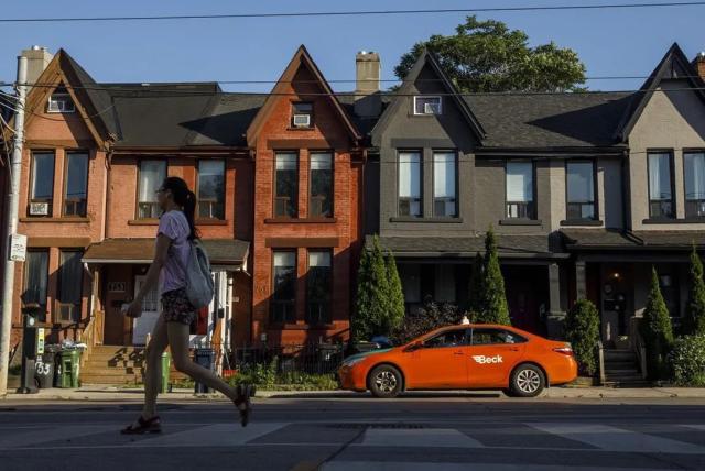 Row of three houses with an orange-red car parked in front