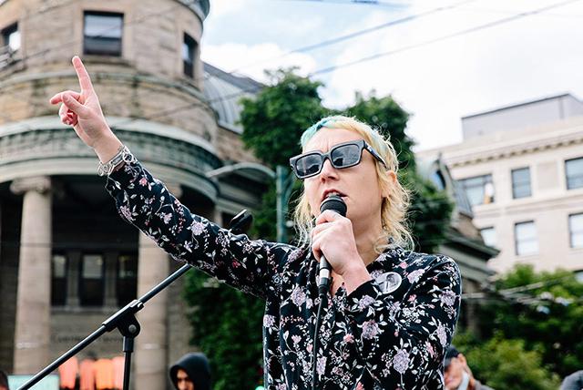 A woman leading a rally, holding a microphone