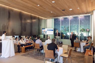 People gathered around listening to a speaker