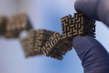 A gloved hand holding cube-like structures