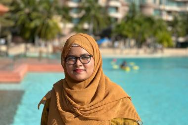 Jasia in front of a tropical beach/pool