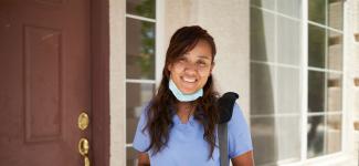A nurse in front of her home