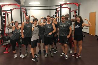 Members of the Nubability coaching team pose for a photo inside a gym with exercise equipment in the background